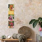 „Flowers 2027“ auf vertikalem Kalender; daneben Tisch mit Dekorationen, Pflanze, Wecker und Decke vor beiger Wand.