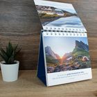 Ein Kalender mit einem Zitat von Tomas Sjödin über die Bedeutung der Stille. Ein Zeltt vor Bergen im Sonnenuntergang.