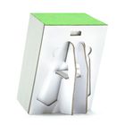 Eine weiße, abstrakte Kartonfigur steht seitlich. Oben ist eine grüne Fläche zu sehen.