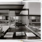 Text: "View north through the living area to the original library/den for a completely transparent view through the house."

Moderner Wohnraum mit großen Glasflächen, Seerosen auf Wasser.