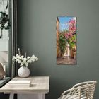 Text: "Zauberhafte Wege". Vertikales Gemälde einer blumengeschmückten Gasse an einer grünen Wand. Tisch mit Blumen.