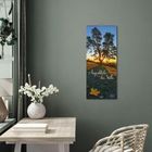 Wandkalender mit Text "Augenblicke der Stille" und "2023", zeigt Sonnenuntergang hinter Bäumen, dekorativer Raum mit Blumen.