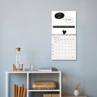 Text: "Du bist doof!", "Du auch", "Liebe kann so einfach sein", "Februar 2022". Wandkalender über einem Regal.