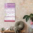 "XL Familien Planer 2027" in großen Buchstaben, darunter ein Familienkalender. Dekorativer Hintergrund mit Pflanzen.