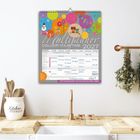 Multyplaner 2027, Colour Your Time. Bunter Kalender mit Eulenmotiv und mehreren Namen in Tabellenform auf einer Küche.