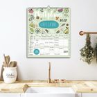 Ein Kalender mit "Multiplaner", "Gute Laune", "2027". Er hängt an einer Wand über einer Spüle in einer Küche.