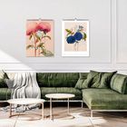 Links steht "BOTANICAL". An der Wand hängen zwei Kalender mit floralen Illustrationen über einem grünen Sofa.