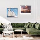 Zwei Kalender an der Wand, einer mit "Sailing 2024", Sofa in Olivgrün, Couchtische, stilvolle Inneneinrichtung.