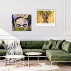 Zwei Kunstkalender an der Wand: "Street Art" mit Blumen, "Gone Beyond the Mesas: From Dream to Reality". Darunter grünliches Sofa.