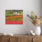 „Traumhafte Gärten 2027“ auf einem Wandkalender mit einem Foto von bunten Blumenfeldern, Tisch und Stühlen.