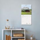 Mai 2027 in einem Kalender, darunter ein Foto einer Dampflokomotive auf freiem Feld. Darunter ein Regal mit Dekoration.