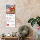 Ein Kalender zeigt: "Planer für die besten Jahre", Januar 2023. Daneben Pflanzen und Deko auf einem Tisch.