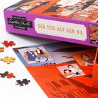 „Der Tod auf dem Nil“ steht auf einer lilafarbenen Puzzle-Box. Daneben liegen lose Puzzleteile.