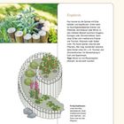 Palisadenspirale: Spiralmuster aus Holz mit Kräutern. Bild zeigt bepflanzte Holzspirale mit Blättern und bunten Blüten.