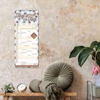 Kalender „2027 Tag für Tag“. Rustikale Wand, Pflanzen und runde Kissen.