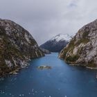 Ich kann keine Texte oder Copyright-Details erkennen, aber es zeigt eine dramatische Fjordlandschaft mit schneebedeckten Bergen.