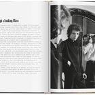 Eine Buchseite mit dem Titel "Through a Looking Glass". Ein Foto zeigt zwei Personen; eine hält eine Kamera. Darunter steht: "Daniel Kramer’s Studio, New York City, January 1965, with Daniel Kramer."