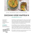 ZUCCHINI-KÄSE-WAFFELN. Rezept für herzhafte Waffeln mit Zucchini, Käse und Kürbiskernen. Bild zeigt goldene Waffeln auf Geschirr.