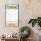 Multiplaner 2017, Gute Laune. Wandkalender mit Blumenmotiv. Sitzkissen und Uhr auf einem Regal.