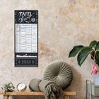 „TAFEL Timer“, „ZETTEL & CO“, ein Wandkalender auf rauer, hellbrauner Wand, daneben Pflanzen und Dekorationen.