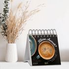 "Kleine Auszeit?" und "2024". Kalender mit zwei Kaffeetassen, eine mit Kaffee gefüllt. Links ist eine weiße Vase mit Trockenblumen.