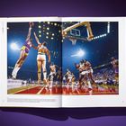 Links: "dominates 1979-1989". Bild: Ein Basketballspiel in einer Arena. Spieler im Sprung, Publikum im Hintergrund.