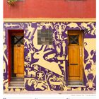 Text: "29 Mo, 30 Di, 31 Mi, 01 Do, 02 Fr, 03 Sa, 04 So, 13. Woche 2027, MÄR / APR."  
Wandgestaltung mit geometrischen Mustern und zwei Holztüren.