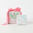 Zwei Geschenke: eines mit rosa Band, Blumenmuster und eines kleineres mit Punktmuster in Pastellfarben.