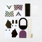 Bastelset mit geometrischen Formen: Streifenmuster, schwarze und violette Teile, Holzstäbe, Draht und Kleinteile.