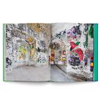 Ein offenes Buch zeigt ein kunstvoll gestaltetes Mosaikzimmer mit spiegelnden Wänden und bunten Details.