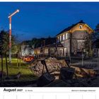 "August 2027", "Bahnhof in Drolshagen-Hützemert". Eine Bahnhofsgebäude-Szene bei Nacht mit einer Lokomotive und Signal.