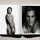 Links ein tätowierter Mann mit Zigarette, rechts ein Mann mit ernstem Gesichtsausdruck im weißen Hemd.