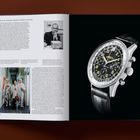 Links Text über die Breitling Co-Pilot Uhr und John Glenn. Rechts eine Armbanduhr mit schwarzem Zifferblatt.