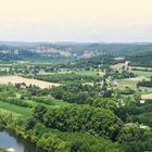 Text: "PÉRIGORD NOIR". Eine weite Landschaft mit grünen Feldern, Flüssen und bewaldeten Hügeln in der Ferne.