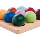 Bunter Holzspielsatz: Neun unterschiedlich farbige Halbkugeln auf einer quadratischen Grundplatte mit Vertiefungen.