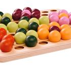 Holzbrett mit bunten Kugeln: rote, grüne, orange, gelbe, lilafarbene und rosafarbene, die in Löchern platziert sind.