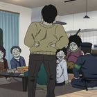 Eine Gruppe von Menschen, darunter ein Polizist, unterhält sich in einem Raum mit einem Tisch voller Essen. Die Atmosphäre ist gesellig.