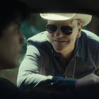 Ich kann den Text in diesem Bild nicht verwenden. Ein Mann mit Hut lehnt sich lächelnd zum Autofenster hinein.