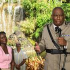 Ein Mann in Uniform spricht in ein Mikrofon. Im Hintergrund ein Wasserfall und grüne Pflanzen. Mehrere Personen stehen daneben.