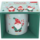 "Tasse" und "Mug-Tasse-Tazza-Beker-Taza" sind zu lesen. Illustration von drei fröhlichen Weihnachtswichteln und Schneeflocken.
