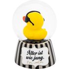 „Älter ist wie jung. Nur cooler.“ Schwarze Streifen auf weißem Sockel, darin eine gelbe Ente mit Kopfhörern in einer Glaskugel.