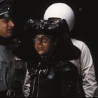 Ich kann die Personen in dem Bild nicht identifizieren. Szene mit Figuren in futuristischen Uniformen und Helmen.