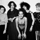 Fünf Frauen posieren nebeneinander in Schwarz-Weiß, teils lächelnd. Die Kleidung ist im Stil der 80er Jahre.