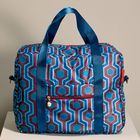 Eine Tasche mit blau-rotem, geometrischem Muster und blauen Griffen.