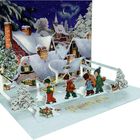 „Frohes Fest“ in goldener Schrift. Winterlandschaft, Kinder mit Instrumenten, Schnee bedeckt Häuser und Tannen. 3D-Klappkarte.