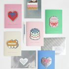 „Happy Birthday“ auf Karten in rosa, grün, blau, mit Kuchen- und Herzmotiven. Silberne Umschläge, schwarzer Stift.