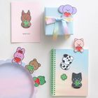 Text "GOOD LUCK"; Illustration von Tieren mit Herzen oder Kleeblättern; pastellfarbene Geschenke und Notizbuch.