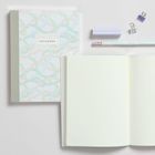 Text: "Notebook", "Lay Flat Binding", "Dotted Pages". Ein Notizbuch mit Punktmusterpapier, Stifte und Büroklammern in Pastellfarben.