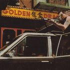 "Golden Dragon" leuchtet auf einem gelben Schild. Ein Mann zielt mit einer Waffe aus dem Schiebedach eines Autos.