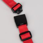 Ein rotes Band mit einem schwarzen Verschlussmechanismus, auf einer hellen Oberfläche liegend.